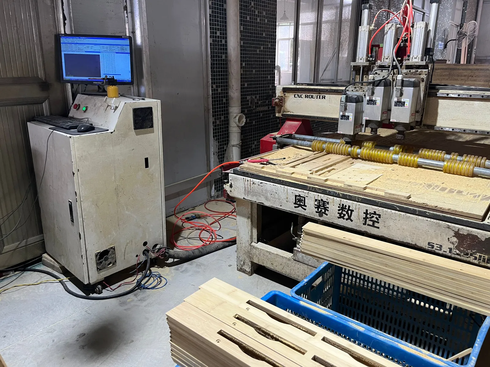 CNC engraving machine with control screen and wooden parts on the bed